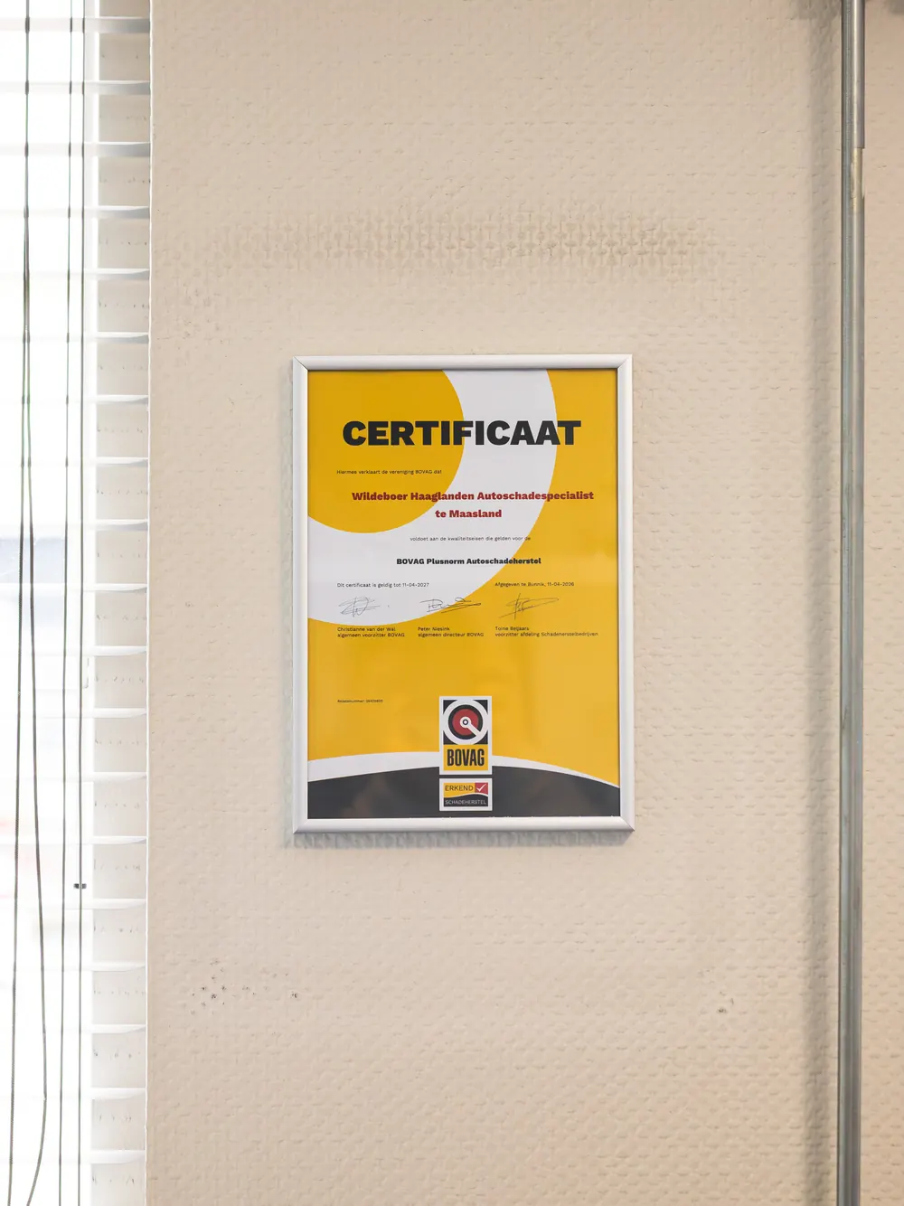 Het BOVAG-certificaat Plusnorm Autoschadeherstel van Wildeboer aan de wand.