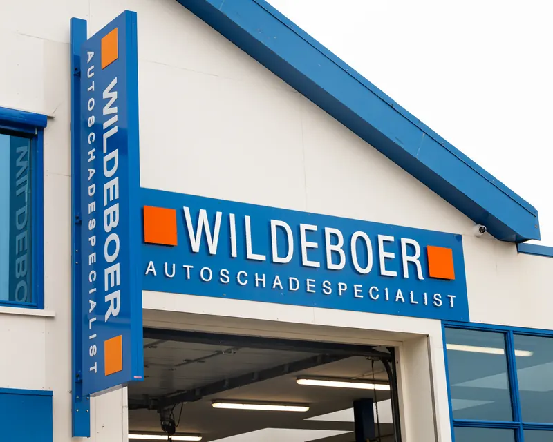 De inrit van de werkplaats van Wildeboer, met de naam op de gevel.