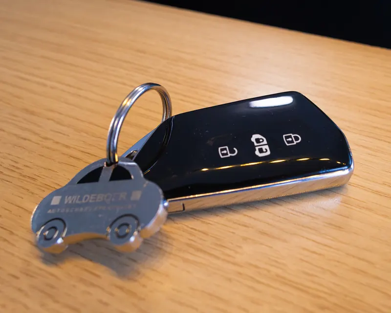 Een autosleutel met een Wildeboer-sleutelhanger op de balie.